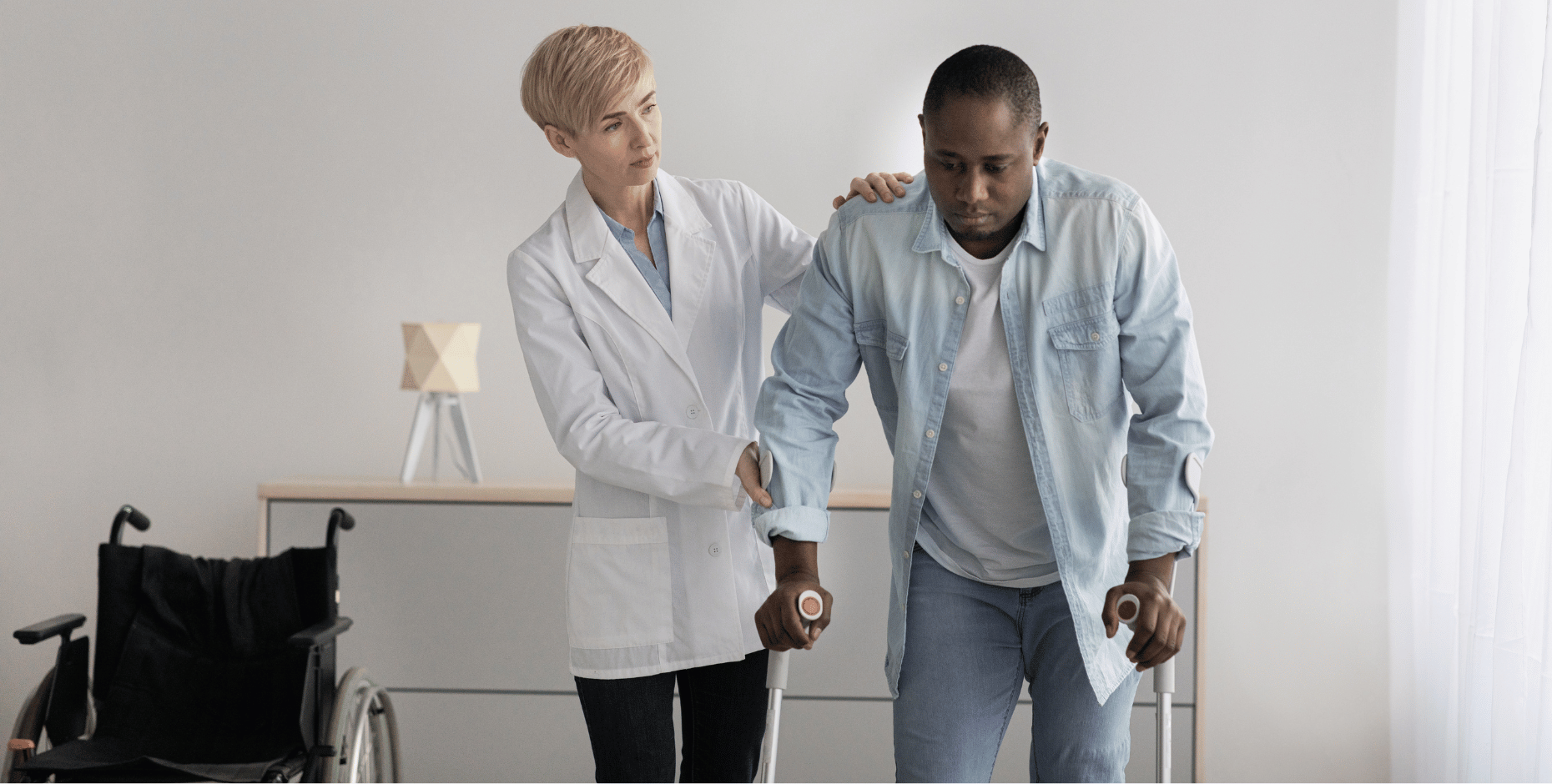 A man on crutches is being assisted by his practitioner