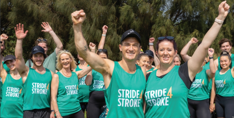 Group of people in Stride4Stroke athletic shirts raising first in air victoriously.